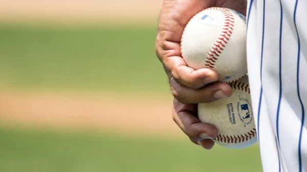 person holding two baseballs