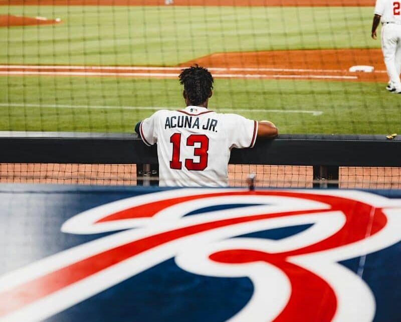 man in white jersey shirt playing baseball